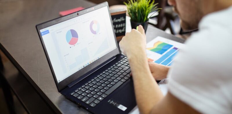 imposter syndrome in SEO - Digital marketer reviewing SEO analytics with a thoughtful expression | Agency coaching session focused on marketing confidence | Freelancer writing a proof-of-work log beside a laptop 1